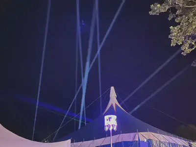 Photo of spotlights above a pointed tent